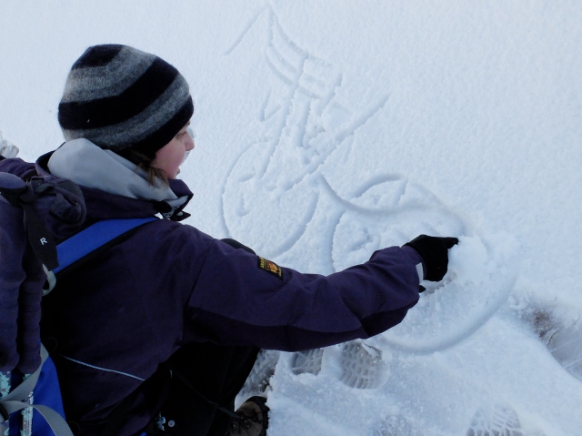 Alison Austin of the John Muir Trust drawing a diagram in the snow of Ben Nevis to explain the mountain’s unique geology